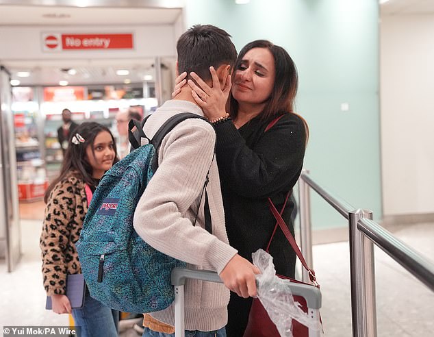 Ahmad Ali, 12, is greeted by his mum, Hafsa, after arriving at Terminal 3 of London Heathrow Airport from Pakistan via Dubai