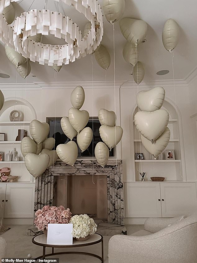 The Love Island star also shared a glimpse into the gender reveal for her unborn child, with a shot of number of cream heart-shaped balloons filling their living room and an envelope that read 'Baby' on the front