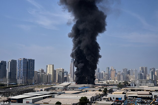 A black plume of smoke rises from a warehouse at the industrial area of Sharjah City in the United Arab Emirates following reports of Iranian strikes in Dubai