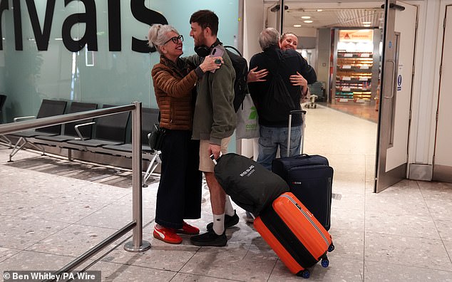 A couple greet their family members upon arrival at Heathrow after taking a flight from Dubai on March 4