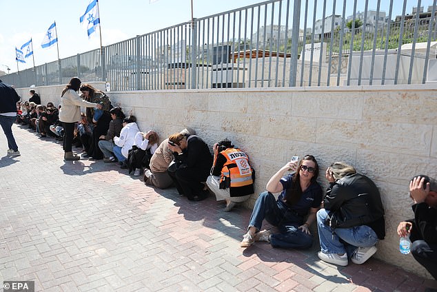 Civilians around me took cover while some ran up the hill to see the interception - within seconds, I could hear the missiles from Gaza  (PICTURED: Civilians taking cover from an Iranian airstrike on February 28)