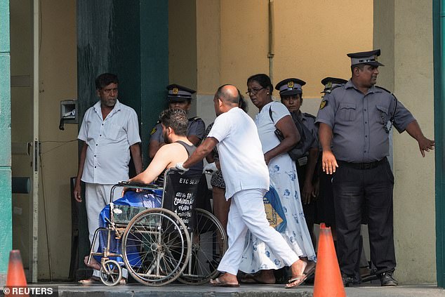On Wednesday night, a further 70 sailors were missing presumed drowned. Pictured: An injured person is transported in a wheelchair at the hospital in Galle, Sri Lanka, to receive treatment after the attack