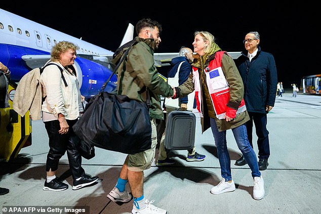Austria's Foreign Minister Beate Meinl-Reisinger welcomes passengers upon the arrival of a charter plane carrying Austrian nationals evacuated from Muscat last night