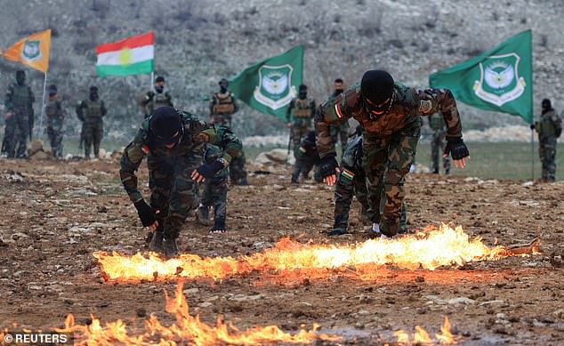 Iranian Kurdish fighters take part in a training session at a base on the outskirts of Erbil, Iraq