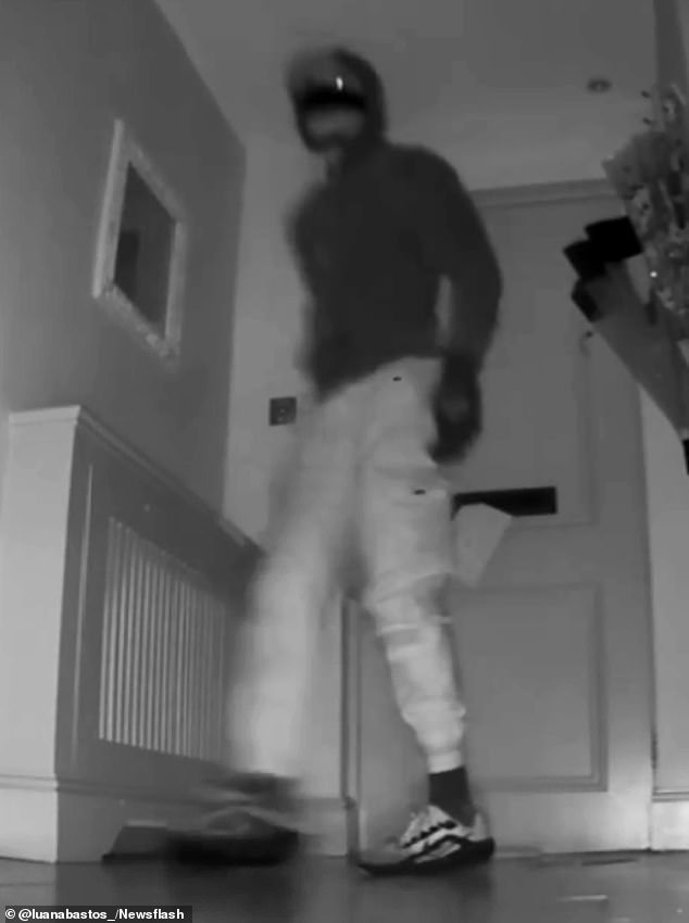 A security camera in the hall captured a thief in a mask and gloves creeping around the house