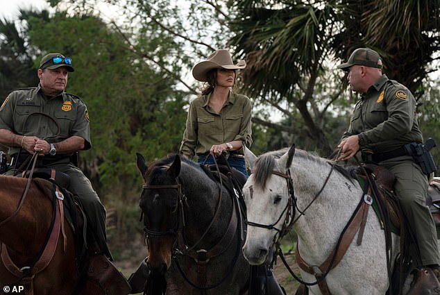 Noem sits atop a horse with Border Patrol agents near the Rio Grande river