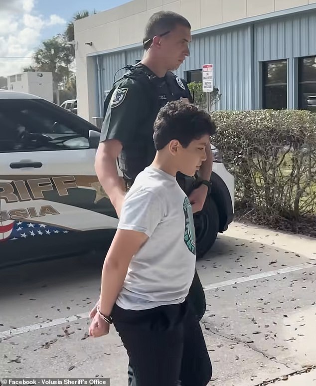 The sheriff's office posted a video of him being escorted inside the police station in handcuffs