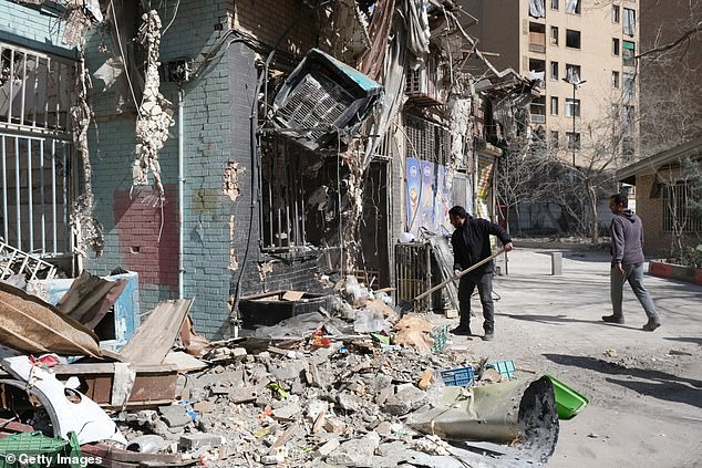 Shop owners clean up the rubble caused by missile explosion in the vicinity of a building in Shahid Borujerdi residential complex in south east Tehran which was heavily struck and destroyed by Israel and the US