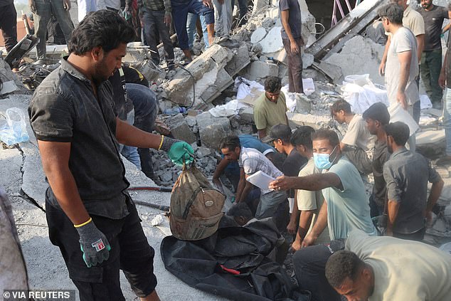 People and rescue forces work following a reported strike on a school in Minab, Iran