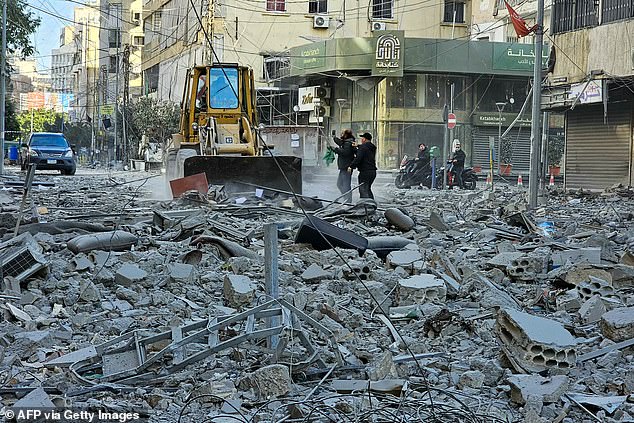 Workers use a bulldozer to clear debris from a street at the site of overnight Israeli airstrikes in the southern suburbs of Beirut on March 6