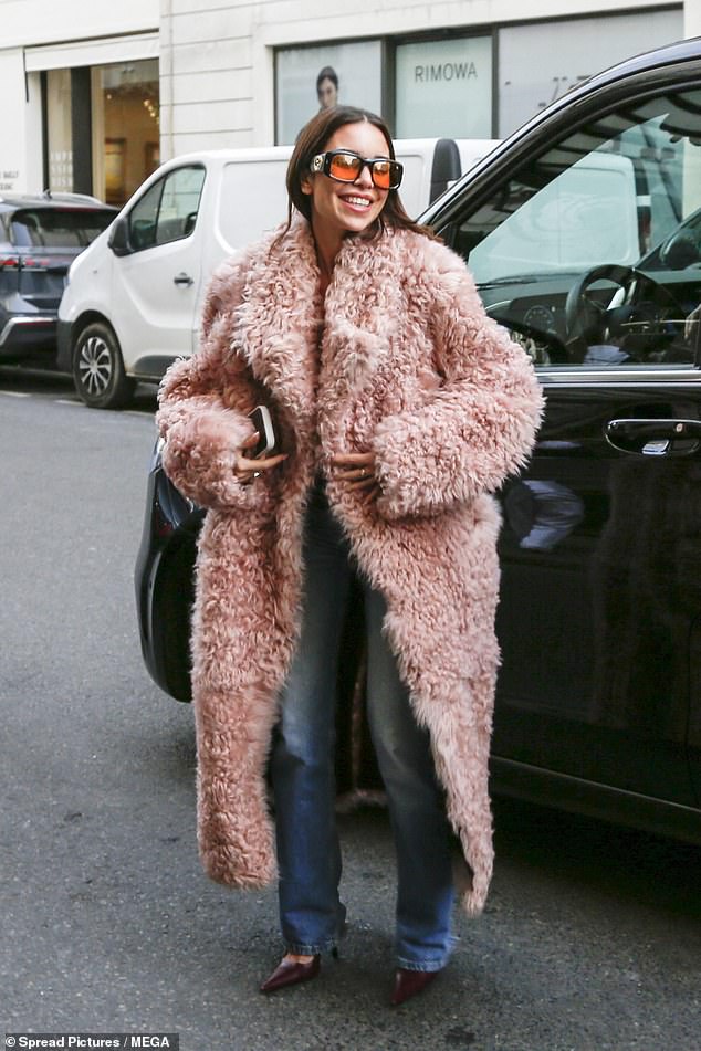 Jackie cut a stylish figure in a statement pink faux-fur coat which she paired with blue denim jeans and chic burgundy high heels