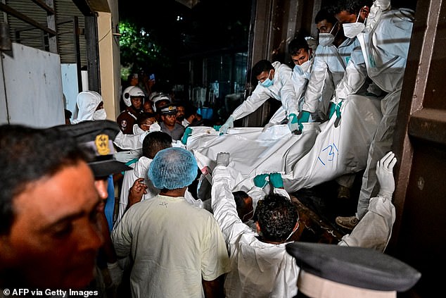 Healthcare workers carry the bodies of Iranian sailors who died in a US torpedo attack on their frigate IRIS Dena
