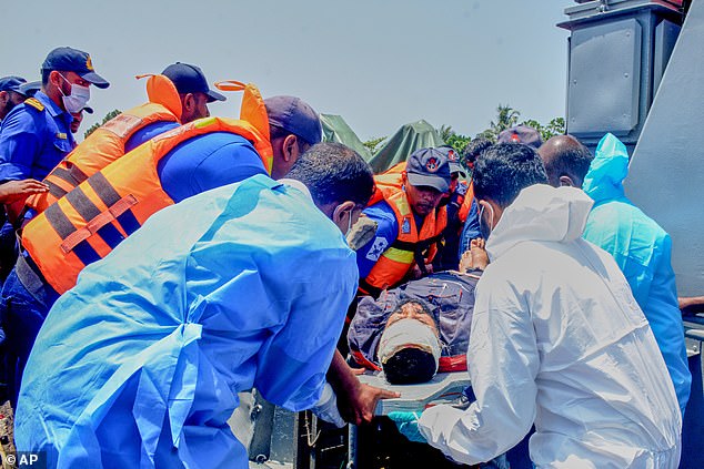 Sri Lankan Navy sailors take one of the injured Iranian sailors from the IRIS Dena warship to hospital