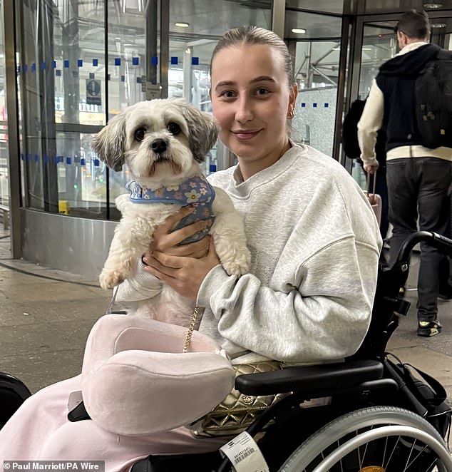 Amelia, having made it safely back to the UK after hiding under her Dubai hotel in a car park, hugs her dog