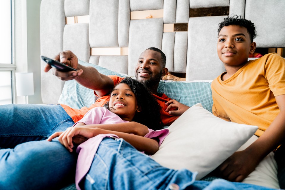 Family watching TV in a bedroom.