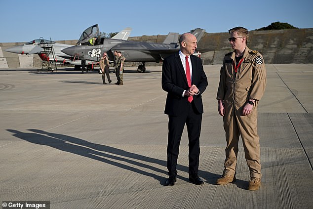 UK Defence Secretary John Healey meets F-35 pilot who shot down a drone as they walk past British typhoon and F-35 jets at RAF Akrotiri on March 5