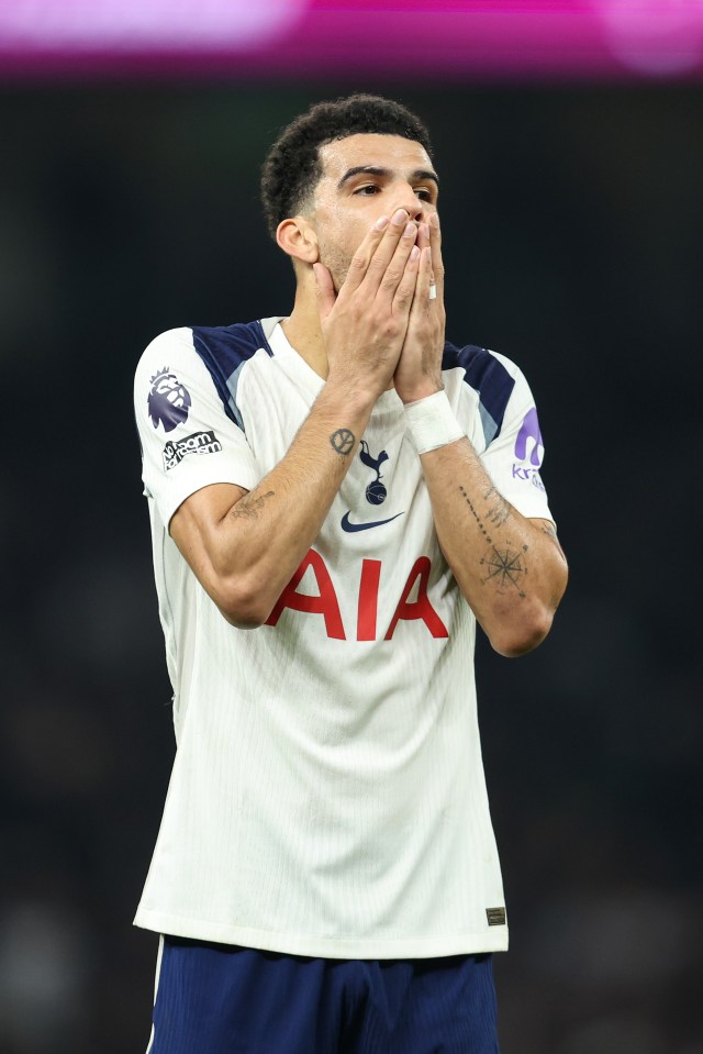 Tottenham Hotspur player Japhet Tanganga covers his mouth with his hands, looking upset.