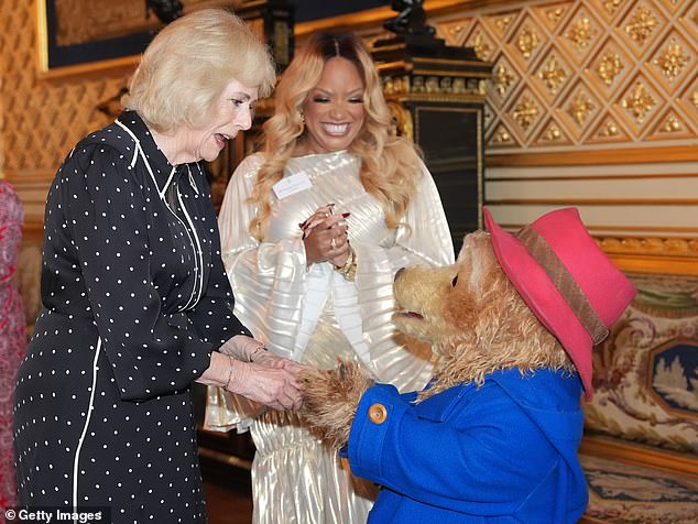 Queen Camilla greets Paddington Bear and Marisha Wallace during a reception with finalists, judges and celebrity readers, to celebrate the final of BBC's creative writing competition 500 Words at Windsor Castle
