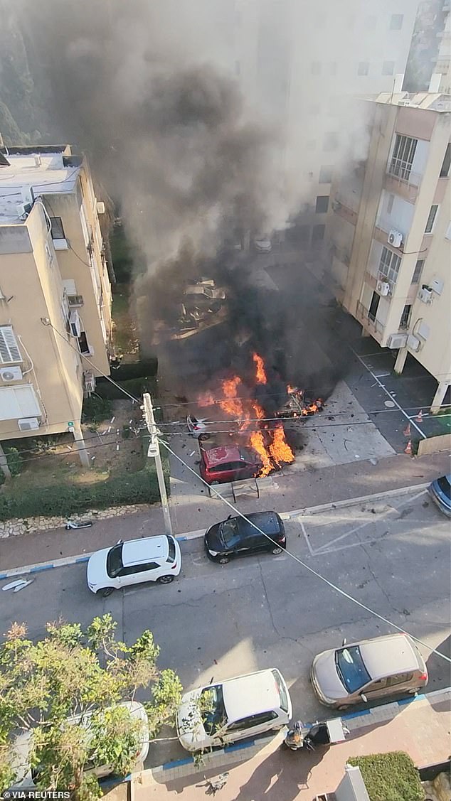 Cars are ablaze amid destruction from an Iranian missile strike in Ramat Gan, Israel, on Tuesday