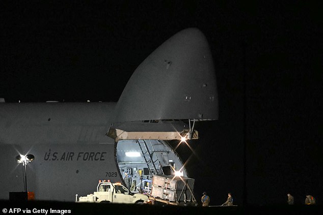Pictured: USAF crew unloading the C-5 Super Galaxy cargo plane at RAF Fairford last night. The biggest plane in the US armoury, its cargo bay can carry two M1 Abrams main battle tanks, six Apache helicopter gunships or up to 36 military vehicles
