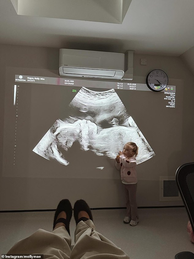 Included in her 'bits and bobs' photo dump was a picture of a recent sonogram of her unborn baby projected onto the wall with her three-year-old daughter Bambi gazing up at it