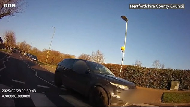 In another clip a car continued driving over the crossing as the guard stepped into the road