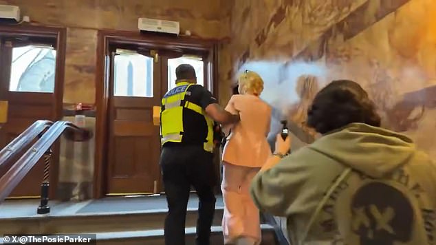 Asking her to 'leave the building immediately', one officer says: 'We've been made aware that you have been asking people questions that have caused them alarm and distress'