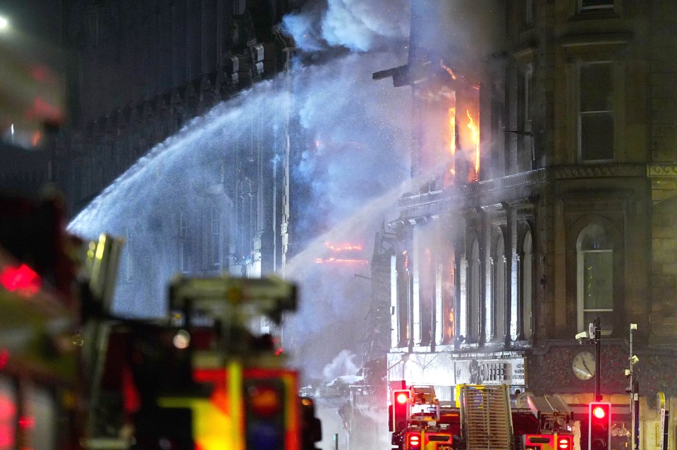A fire burning in a building next to Glasgow Central Station as firefighters try to extinguish it.