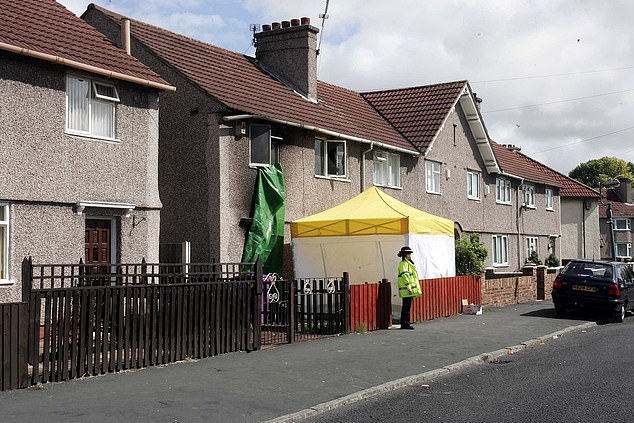 Police outside Ms Hargreaves' home, where two men burst in and shot her dead before setting it alight