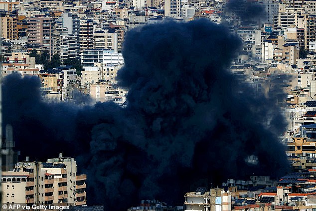An enormous cloud of dark smoke rises above Beirut following Israeli shelling on the Iranian capital