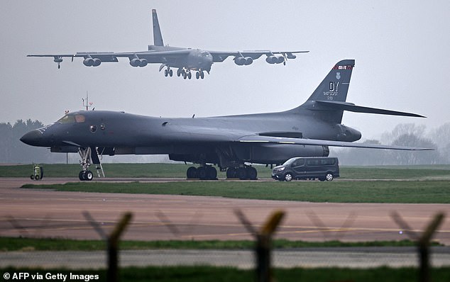 A US Air Force Boeing B-52 Stratofortress bomber jet lands on the runway, beyond a USAF Rockwell B-1 Lancer bomber jet, at RAF Fairford in south west England on March 9,
