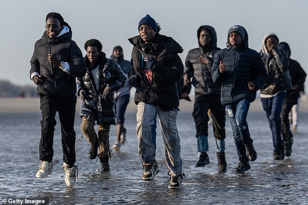 Migrants were pictured sprinting across Gravelines beach in France last week to board a UK-bound smugglers' dinghy