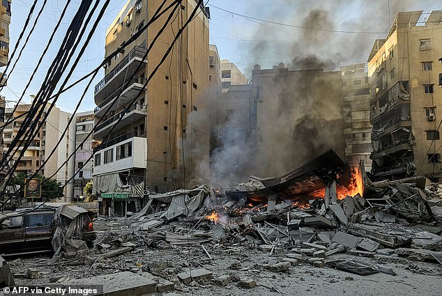 A fire burns at the site of a collapsed building following an Israeli airstrike on Beirut's southern suburbs on March 9