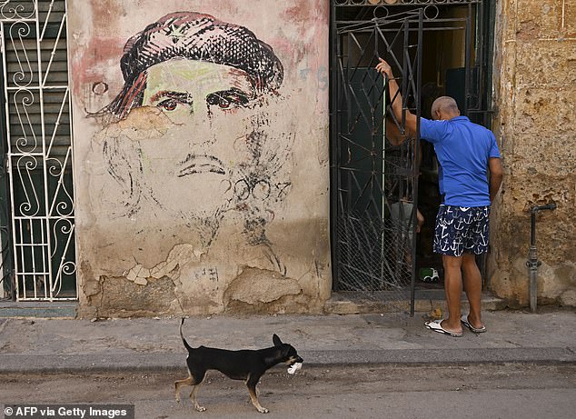 A man enters his home next to a mural depicting Argentine-born revolutionary leader, Ernesto 'Che' Guevara, after a power outage in Havana last week