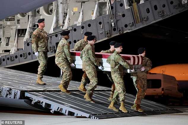 Members of the military carry the transfer case during a dignified transfer of the remains of Sgt Pennington