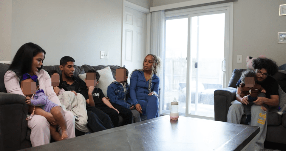 Two men and two women co-parenting five children together in a living room.