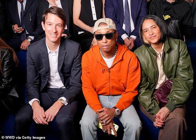 Pharrell (centre) the men's creative director for Louis Vuitton, sat in the front row alongside his wife Helen Lasichanh Williams and French businessman Alexandre Arnaul