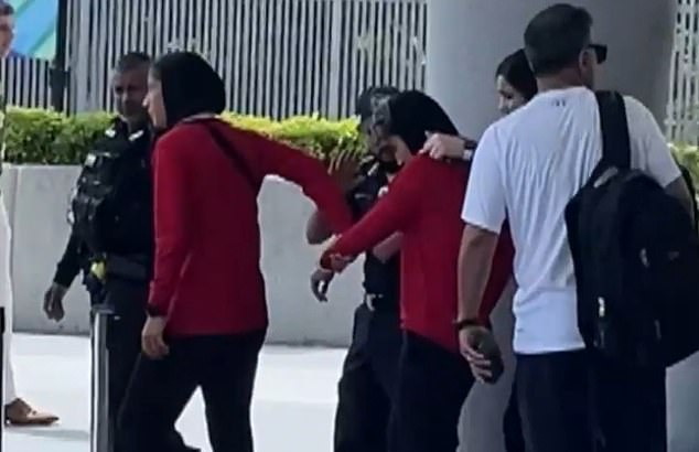 One player appeared to be led by the hand onto the bus by a teammate