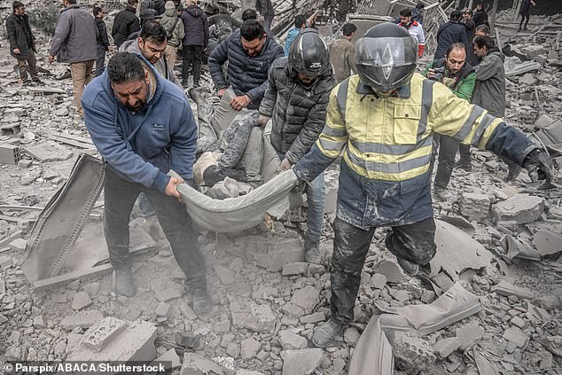 A body is carried from the rubble following an air strike in Ferdowsi square in central Tehran, Iran on March 3