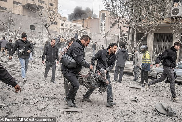 A body is carried by rescuers after a blast struck Ferdowsi square in central Tehran, Iran on March 3