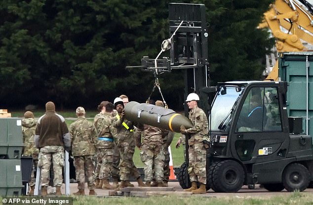 Members of the US Air Force (USAF) lift missiles and bombs for loading on to planes at RAF Fairford