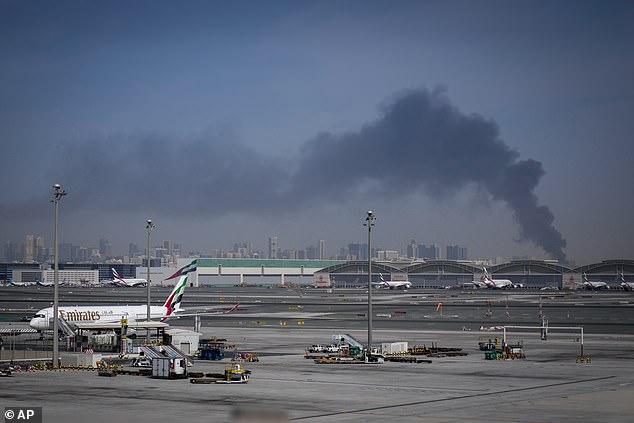 It came amid retaliatory Iranian strikes in the United Arab Emirates (UAE) and across the broader Gulf region after Iran was attacked by the US and Israel on February 28. Pictured: Emirates planes parked at Dubai International Airport after it closed, with a plume of smoke in the background from an Iranian strike, on March 1