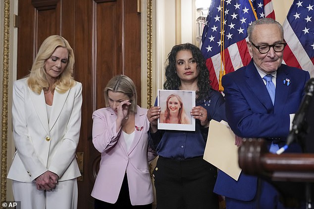 Sharlene Rochard (second right) holds a photograph of Virginia Giuffre as she stands next to Senate Minority Leader Chuck Schumer at the US Capitol in Washington on February 10