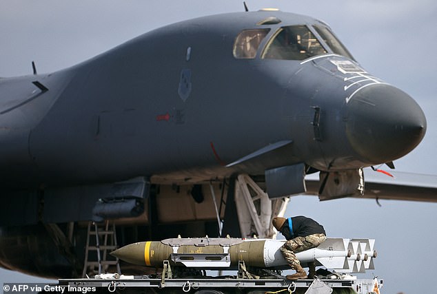 Military ground personnel work on Joint Direct Attack Munitions (JDAM) in front of a US Air Force (USAF) B-1 Lancer bomber at RAF Fairford today