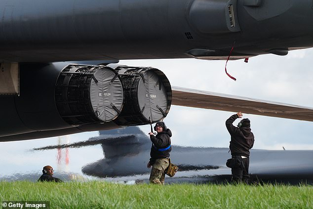 Heat haze from engines warms technicians as US bombers are primed for missions