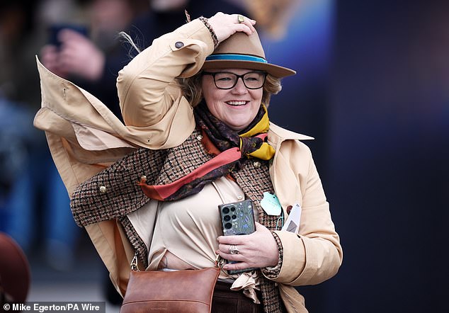 Hold on to your hats! One woman battles the windy conditions on day three of the festival