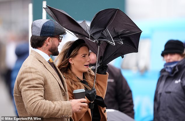 Racegoers battle with the windy conditions on day three of the 2026 Cheltenham Festival