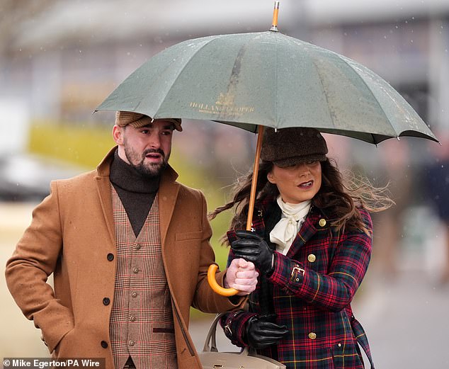 Looking glam together! A pair appear equally stylish as they shelter under one umbrella