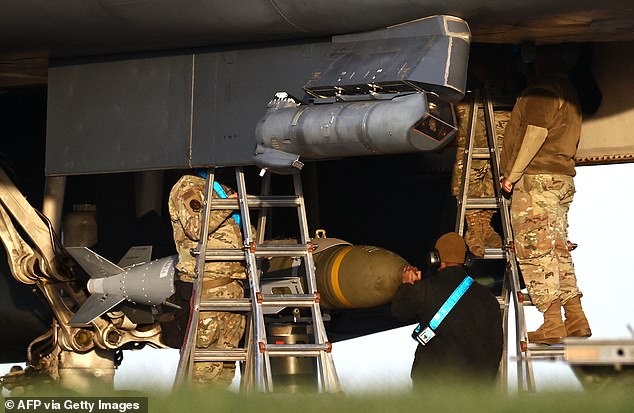 USAF military ground personnel load Joint Direct Attack Munitions (JDAM) into a US Air Force (USAF) B-1 Lancer bomber on the tarmac at RAF Fairford in south-west England on March 11