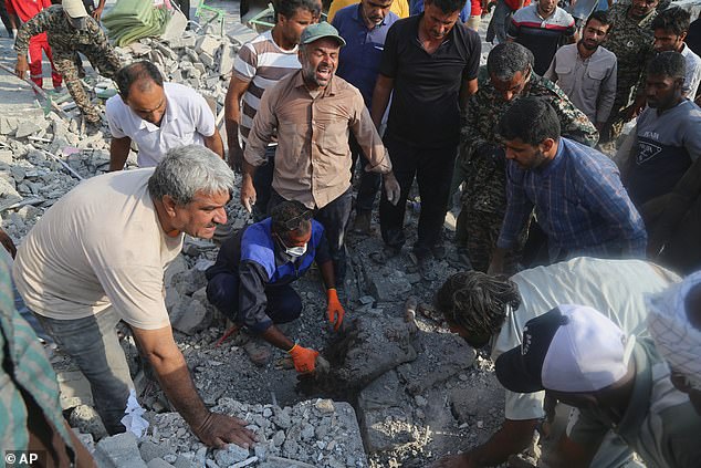 Rescue workers and residents search through the rubble in the aftermath of the strike on Shajareh Tayyebeh primary school